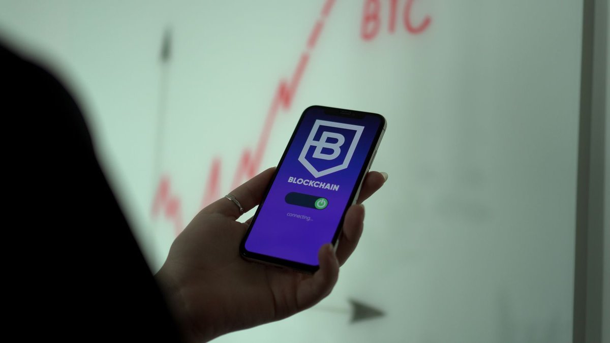 Mão segurando celular com aplicativo de carteira quente de criptomoeda aberto