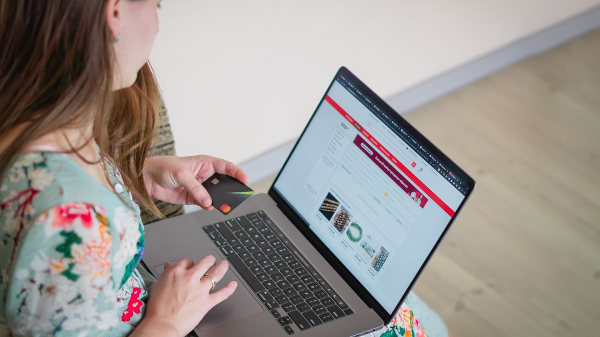 Mulher fazendo compra online pelo notebook com cartao de credito