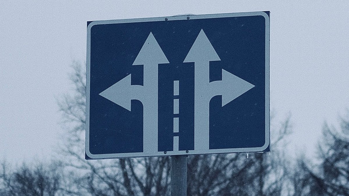 Placa de sinalização com setas apontando em direções diferentes
