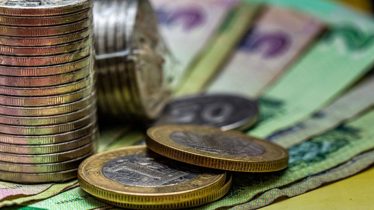 Moedas e notas de real empilhadas sobre a mesa