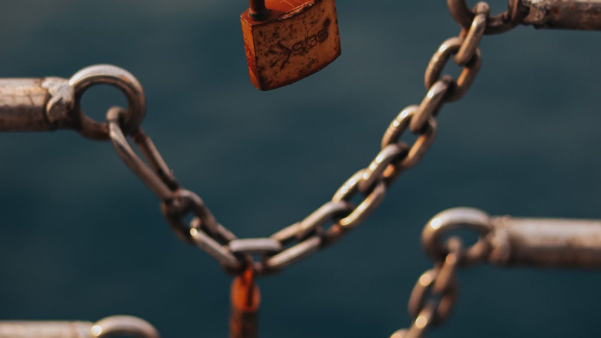 Cadeado preso numa corrente de metal, representando valor travado em staking